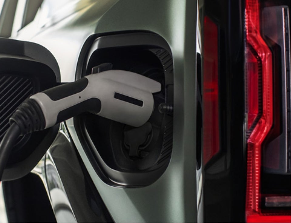 Close up of charging port with charger plugged in on a GMC Hummer EV SUV - Wilhelm GMC in Jamestown ND